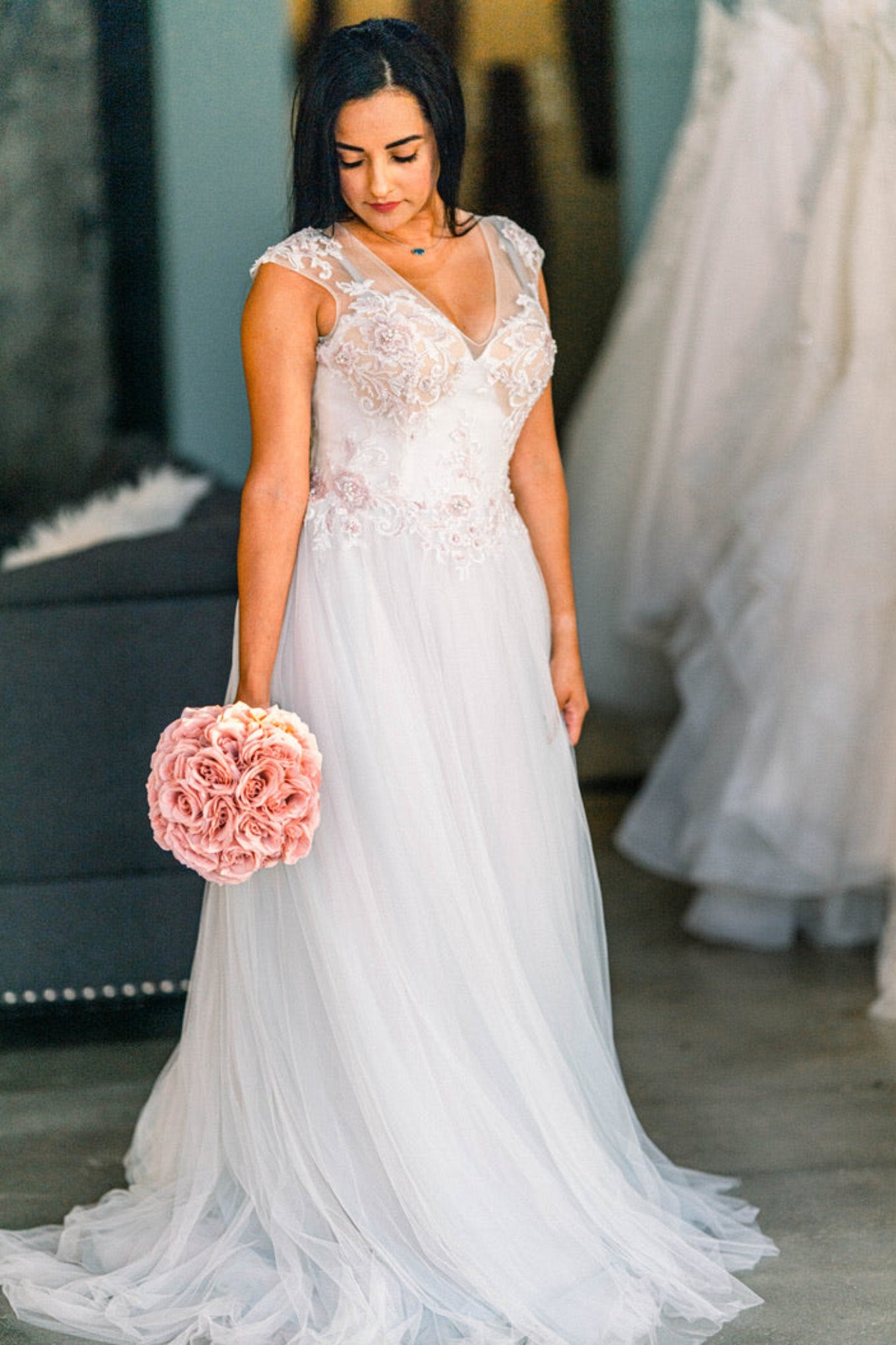 Model holding artificial flower bouquet in Randy Fenoli dress, Bella Rose, in size 6. 