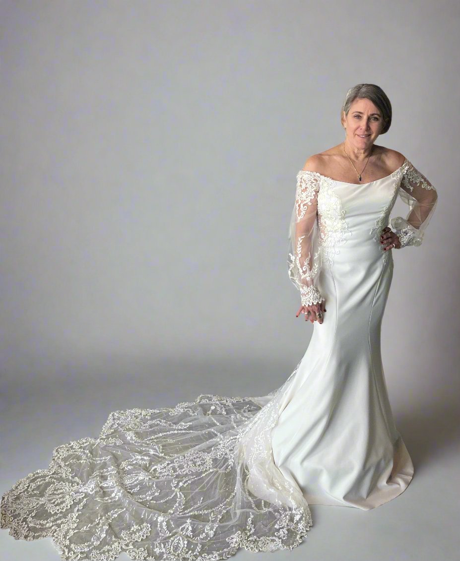 Model wearing Randy Fenoli wedding dress, Dominique, in white with lace shoulder sleeves in size 6